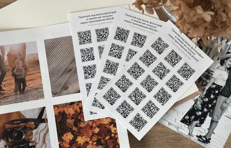 Листы круглых QR-наклеек веером поверх напечатанных фотографий